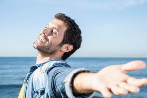 Man with eyes closed smiling on the beach
