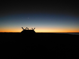 The sun just rising on the horizon, the moon and a single star hovering above the makeshift tent we built on the desert island.